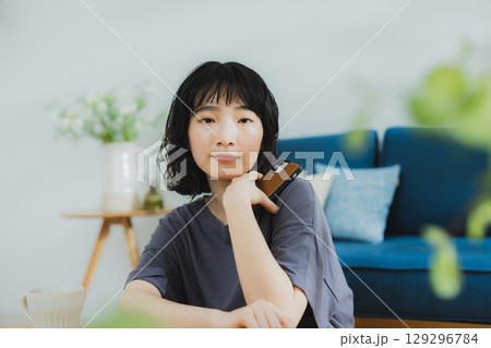 自宅でくつろぐ若い女性 自宅でくつろぐ若い女性 129296784