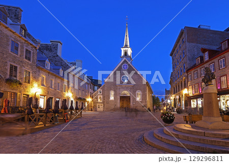 Tourists enjoying walking in Old Quebec streets, including Quebecois Fresco and Notre Dame des Victories church in Place Royale Tourists enjoying walking in Old Quebec streets, including Quebecois Fresco and Notre Dame des Victories church in Place Royale 129296811