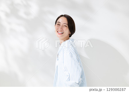 木漏れ日の中に立つ笑顔の女性 木漏れ日の中に立つ笑顔の女性 129300287