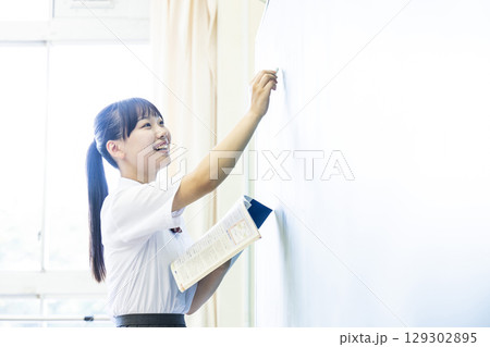 黒板に文字を書く女子高生 129302895