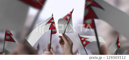 Nepal flags in their hands on a blurred urban background Nepal flags in their hands on a blurred urban background 129303512