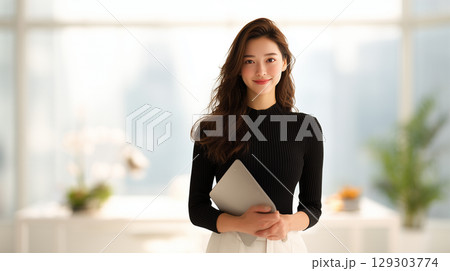 女性がオフィスでクリップボードを持つ姿 女性がオフィスでクリップボードを持つ姿 129303774