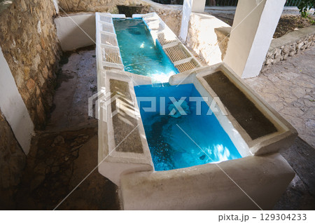 Natural Stone Structure Featuring a Vintage Clean Water Trough Under Natural Light 129304233