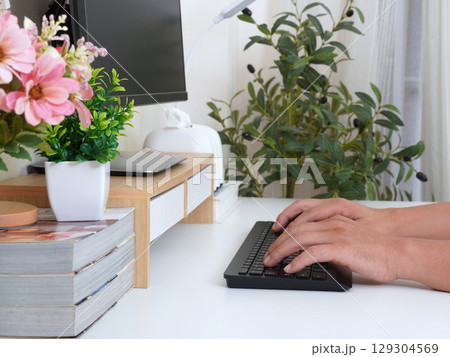 Modern workspace with hands typing on keyboard Modern workspace with hands typing on keyboard 129304569