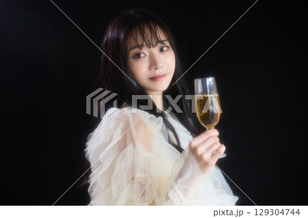 暗い背景でドレスを着た若い女性の高級感のある美容ファッションポートレート 129304744