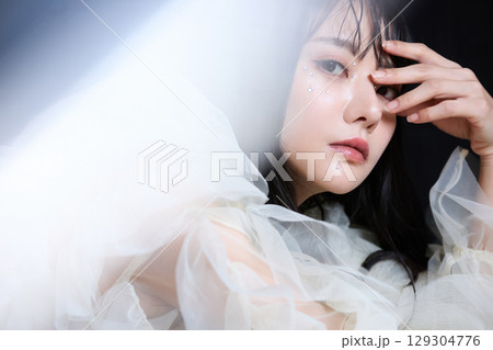 暗い背景でドレスを着た若い女性の高級感のある美容ファッションポートレート 129304776