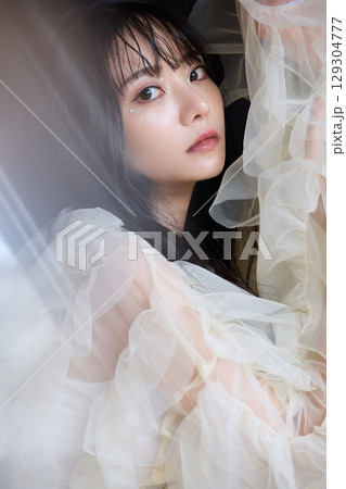 暗い背景でドレスを着た若い女性の高級感のある美容ファッションポートレート 129304777