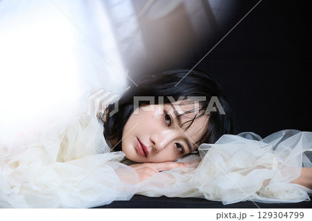 暗い背景でドレスを着た若い女性の高級感のある美容ファッションポートレート 129304799