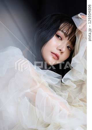暗い背景でドレスを着た若い女性の高級感のある美容ファッションポートレート 暗い背景でドレスを着た若い女性の高級感のある美容ファッションポートレート 129304806