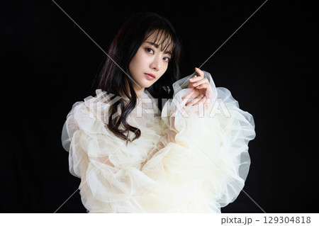 暗い背景でドレスを着た若い女性の高級感のある美容ファッションポートレート 129304818