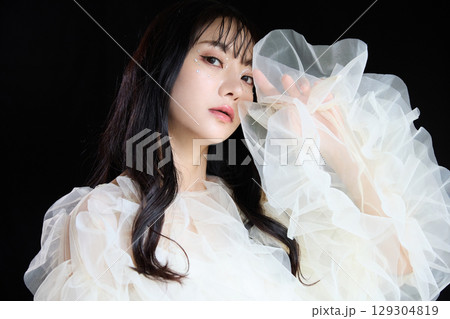暗い背景でドレスを着た若い女性の高級感のある美容ファッションポートレート 129304819
