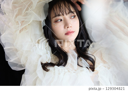 暗い背景でドレスを着た若い女性の高級感のある美容ファッションポートレート 129304821