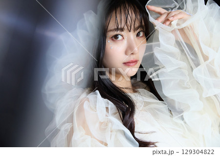 暗い背景でドレスを着た若い女性の高級感のある美容ファッションポートレート 129304822