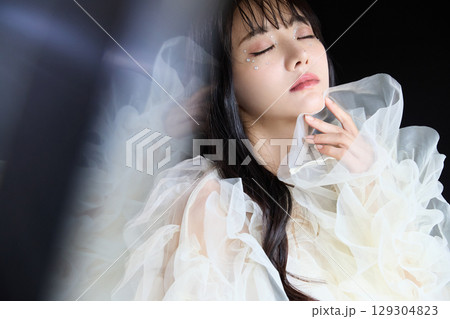 暗い背景でドレスを着た若い女性の高級感のある美容ファッションポートレート 129304823