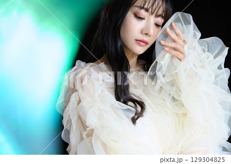 暗い背景でドレスを着た若い女性の高級感のある美容ファッションポートレート 129304825