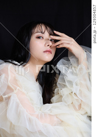 暗い背景でドレスを着た若い女性の高級感のある美容ファッションポートレート 暗い背景でドレスを着た若い女性の高級感のある美容ファッションポートレート 129304857