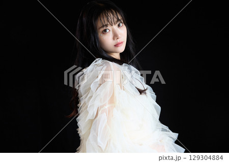 暗い背景でドレスを着た若い女性の高級感のある美容ファッションポートレート 129304884