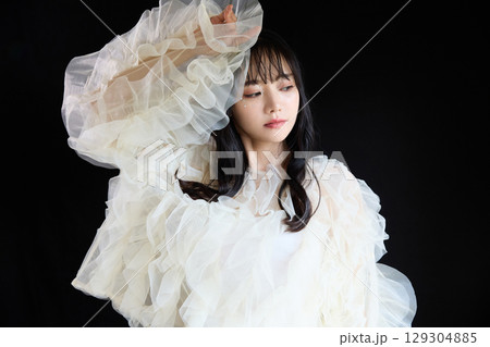 暗い背景でドレスを着た若い女性の高級感のある美容ファッションポートレート 129304885