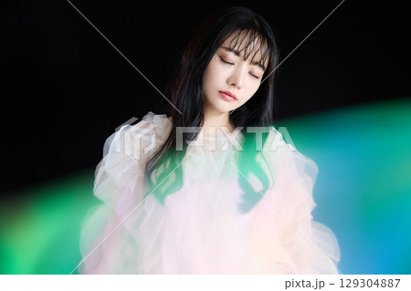 暗い背景でドレスを着た若い女性の高級感のある美容ファッションポートレート 129304887