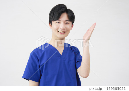 医者・看護師・歯科医師・介護士 右側を手のひらで指す男性 白背景 医者・看護師・歯科医師・介護士 右側を手のひらで指す男性 白背景 129305021