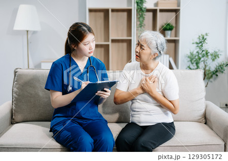 Asian caregiver doctor examine older patient use blood pressure gauge. woman therapist nurse at nursing home taking care of senior elderly Asian caregiver doctor examine older patient use blood pressure gauge. woman therapist nurse at nursing home taking care of senior elderly 129305172