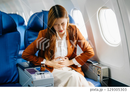 Photo of a frustrated woman sitting on an airplane with her head in her hands Photo of a frustrated woman sitting on an airplane with her head in her hands 129305303