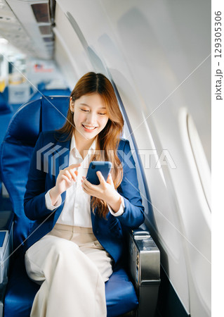 Young Asian executive excels in first class, multitasking with digital tablet, laptop and smartphone Young Asian executive excels in first class, multitasking with digital tablet, laptop and smartphone 129305306