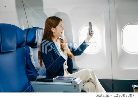 Young Asian executive excels in first class, multitasking with digital tablet, laptop and smartphone Young Asian executive excels in first class, multitasking with digital tablet, laptop and smartphone 129305307
