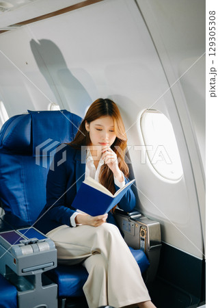 Young Asian executive excels in first class, multitasking with digital tablet, laptop and smartphone Young Asian executive excels in first class, multitasking with digital tablet, laptop and smartphone 129305308