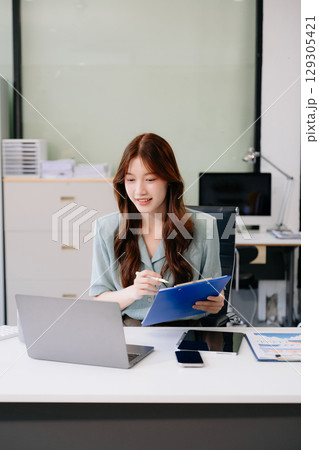 Business woman using tablet and laptop for doing math finance on an office desk, tax, report, accounting, 129305421