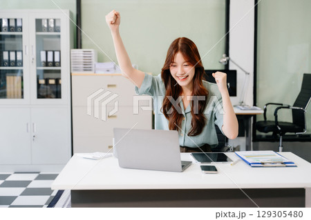 Asian business woman are delighted and happy with the work they do on their tablet, laptop and taking notes Asian business woman are delighted and happy with the work they do on their tablet, laptop and taking notes 129305480