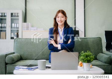 Businesswomen brainstorming in a cozy office, collaborating with a laptop and notebook 129305541