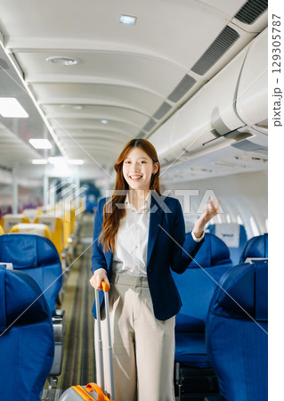 Asian female passenger of airplane sitting in comfortable seat while working laptop and tablet. Travel in style, Asian female passenger of airplane sitting in comfortable seat while working laptop and tablet. Travel in style, 129305787