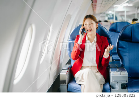 Young Asian executive excels in first class, multitasking with digital tablet, laptop and smartphone. Travel in style, work Young Asian executive excels in first class, multitasking with digital tablet, laptop and smartphone. Travel in style, work 129305822