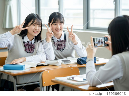 教室でスマホ撮影をする笑顔の女子生徒 129306048