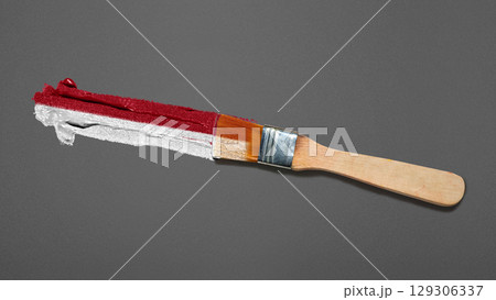 Closeup view of the red and white colors of the Indonesian national flag with a black wall background. Celebrate Indonesia Independence Day. Concept of Kemerdekaan Indonesia 129306337