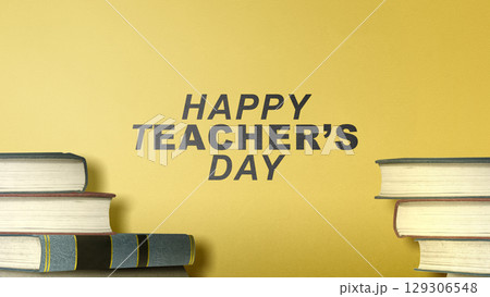 Stack of books with the message of World Teacher Day on a yellow background. Concept of World Teacher Day Stack of books with the message of World Teacher Day on a yellow background. Concept of World Teacher Day 129306548