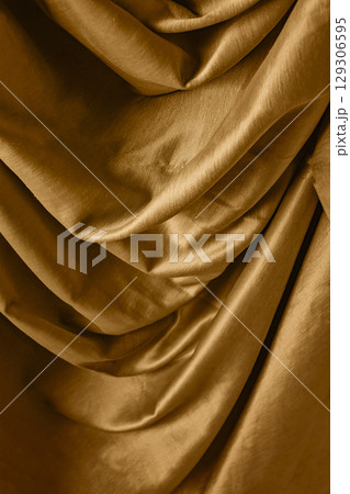 Golden satin silk with crumpled abstract texture background. Material textile surface. Copy space Golden satin silk with crumpled abstract texture background. Material textile surface. Copy space 129306595
