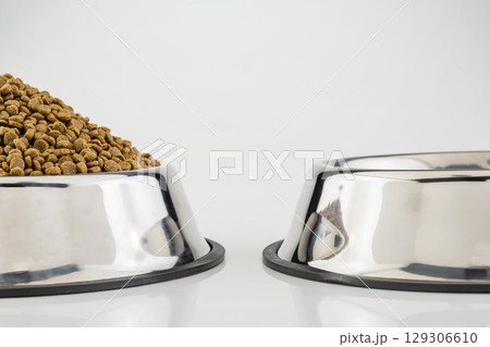 Dog and cat dry food on a stainless steel bowl on a white background 129306610