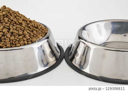 Dog and cat dry food on a stainless steel bowl on a white background Dog and cat dry food on a stainless steel bowl on a white background 129306611