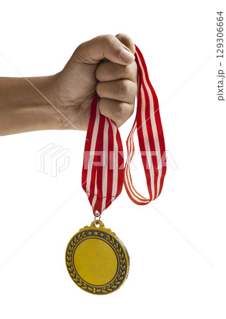 Human hand holding golden award medal suspended from a red and white striped ribbon isolated over a white background. Copy space. Symbol of achievement, recognition, or competition Human hand holding golden award medal suspended from a red and white striped ribbon isolated over a white background. Copy space. Symbol of achievement, recognition, or competition 129306664