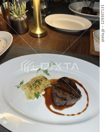 Grilled beef steak with a smoky char and infused with aromatic herbs. The perfect blend of flavors and enticing aroma makes every bite a savory delight. Grilled beef steak with a smoky char and infused with aromatic herbs. The perfect blend of flavors and enticing aroma makes every bite a savory delight. 129307131