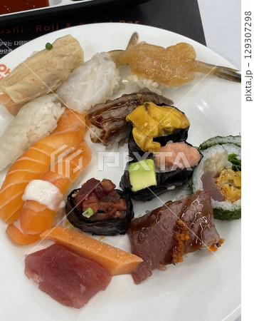 An assortment of fresh sushi, artfully arranged with a variety of toppings and vibrant colors. This traditional Japanese dish combines vinegared rice, seafood, and vegetables for an experience. 129307298
