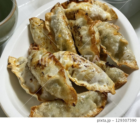 Delicious Korean mandu dumplings with a golden, crispy exterior and flavorful filling. Perfect as an appetizer, snack, or side dish, offering a delightful taste in every bite. Delicious Korean mandu dumplings with a golden, crispy exterior and flavorful filling. Perfect as an appetizer, snack, or side dish, offering a delightful taste in every bite. 129307390