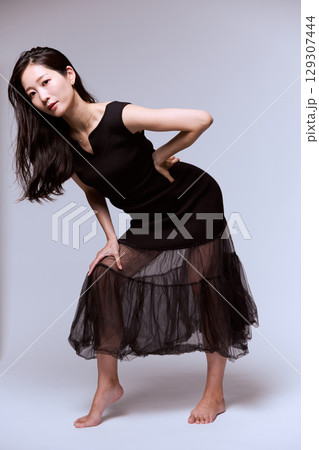 黒いドレスでポージングする女性モデルのスタジオポートレート 黒いドレスでポージングする女性モデルのスタジオポートレート 129307444