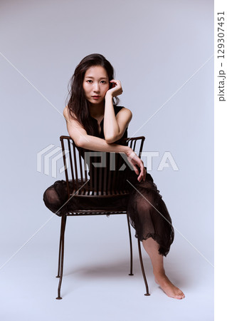 黒いドレスでポージングする女性モデルのスタジオポートレート 129307451