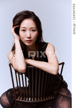 黒いドレスでポージングする女性モデルのスタジオポートレート 129307459