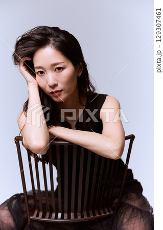 黒いドレスでポージングする女性モデルのスタジオポートレート 129307461