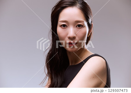 黒いドレスでポージングする女性モデルのスタジオポートレート 129307473