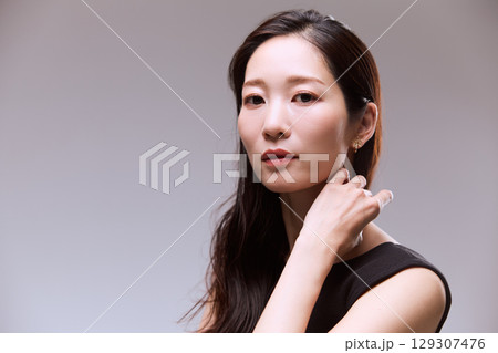 黒いドレスでポージングする女性モデルのスタジオポートレート 黒いドレスでポージングする女性モデルのスタジオポートレート 129307476